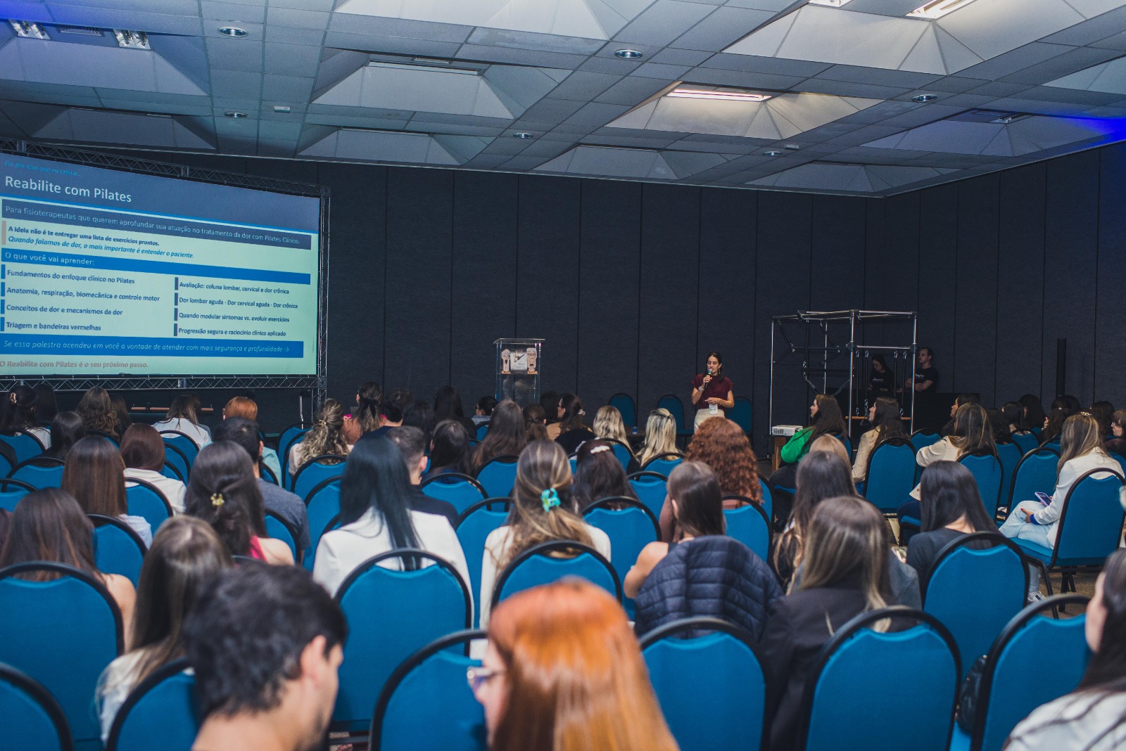 Palestra em congresso de fisioterapia com auditório lotado
